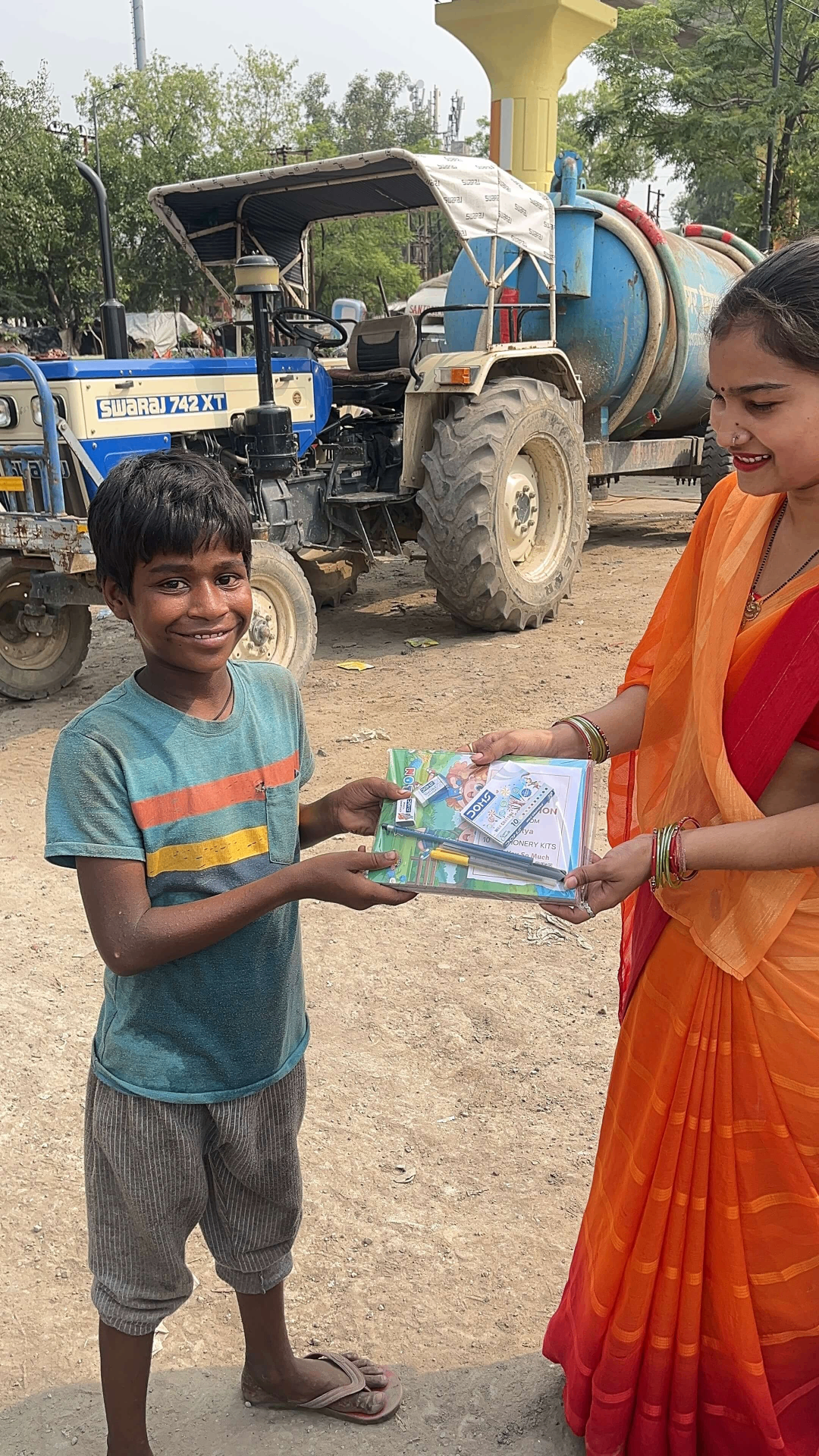 A smiling boy holding his new school stationery kit from Kindpath Foundation